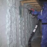 Louis spraying Gaco foam insulation in Lacy's trailer.