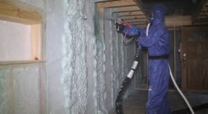 Louis spraying Gaco foam insulation in Lacy's trailer.