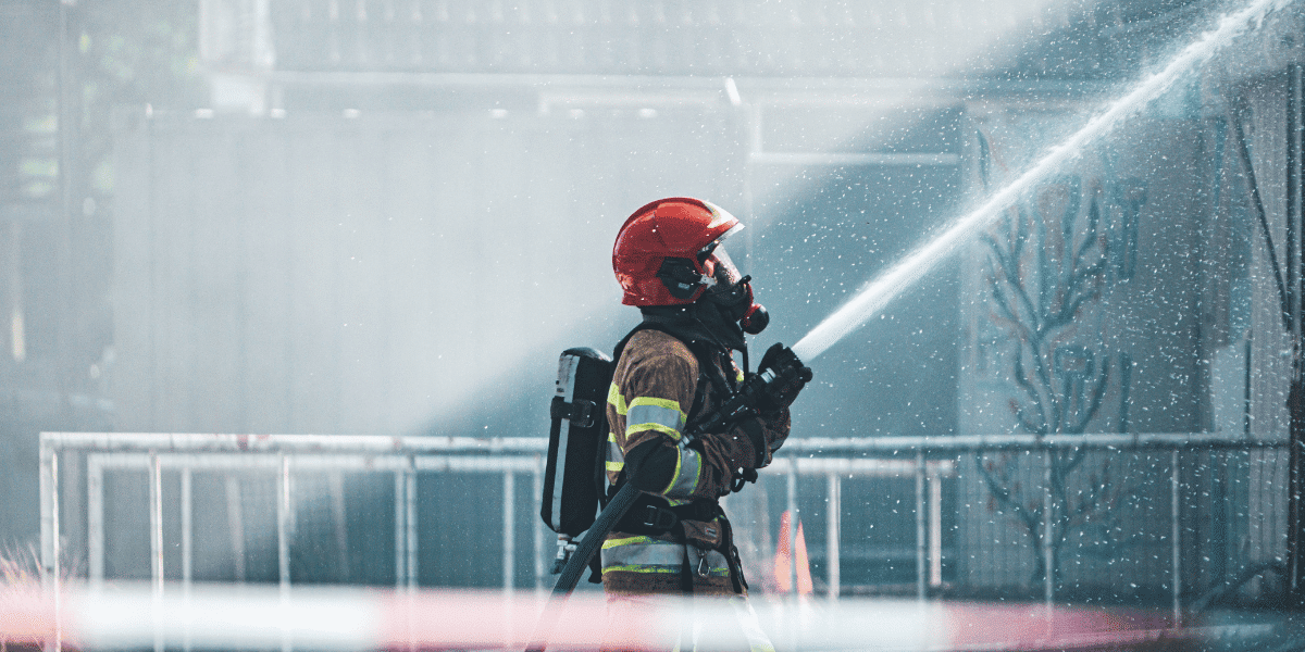 A fireperson extinguishing an industrial fire