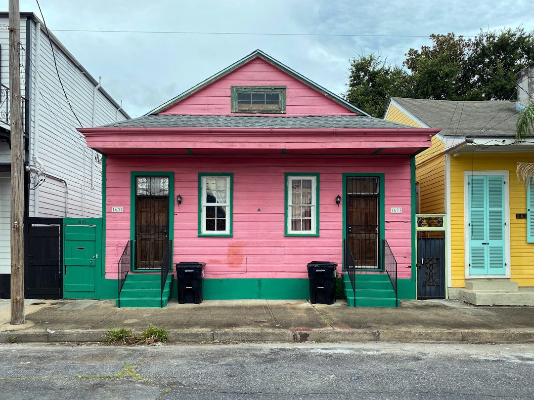 The base of a traditional New Orleans house, showing the foundation meeting the ground on a bright, sunny day, setting the scene for a local homeowner.