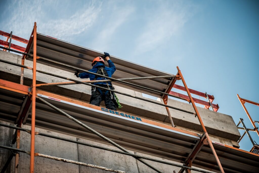 Professional contractor in protective gear carefully applies spray foam insulation to the interior wall of a home under co...
