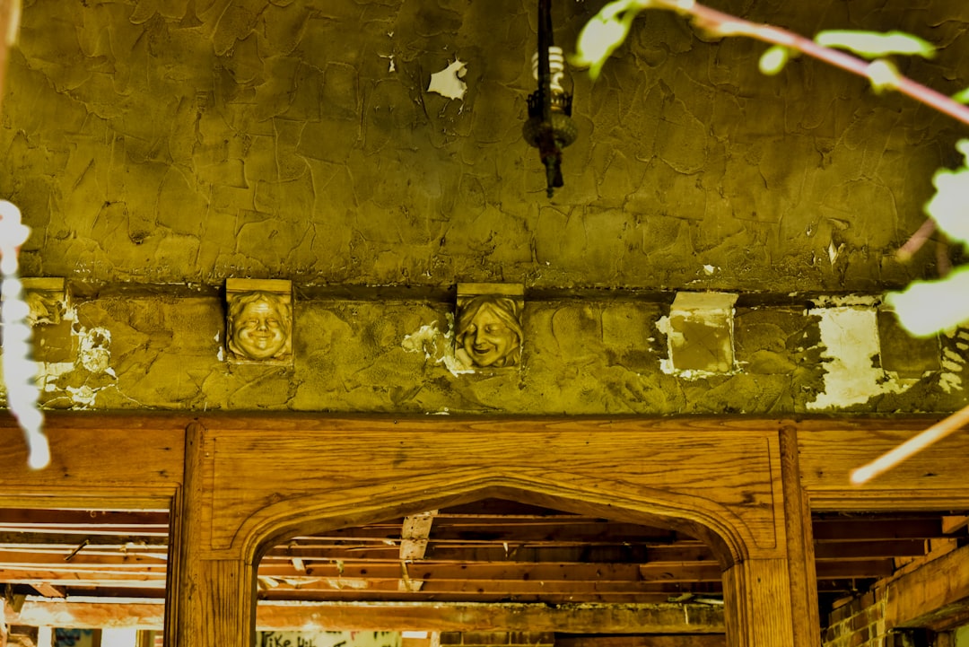 A detailed close-up shot of a peeling, water-stained wooden ceiling, clearly showing the effects of hidden moisture damage in a home.