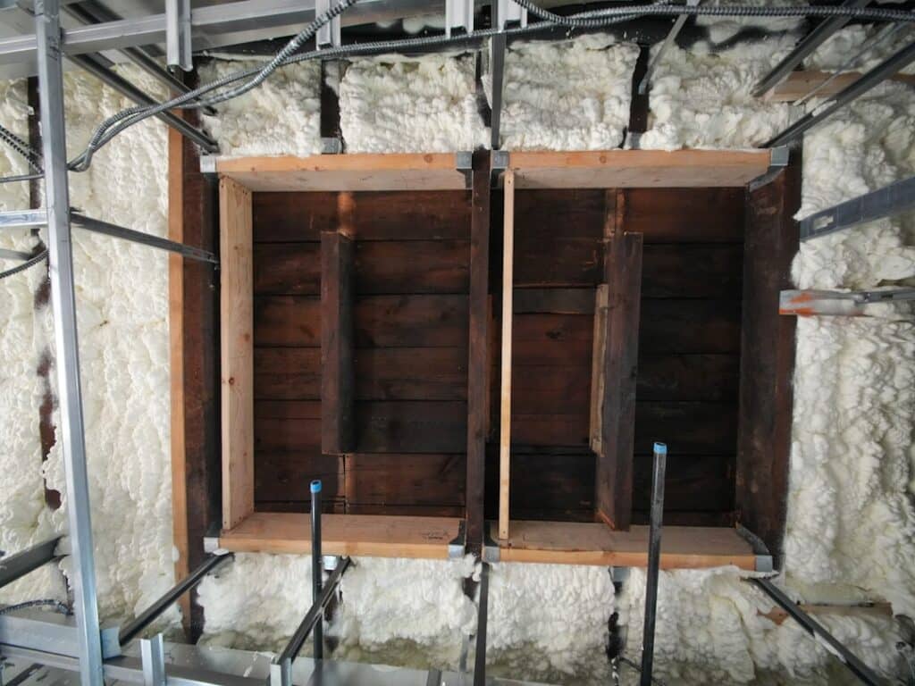 Close-up view of water stains and moisture damage on wooden ceiling planks, illustrating the potential for roof deck rot.