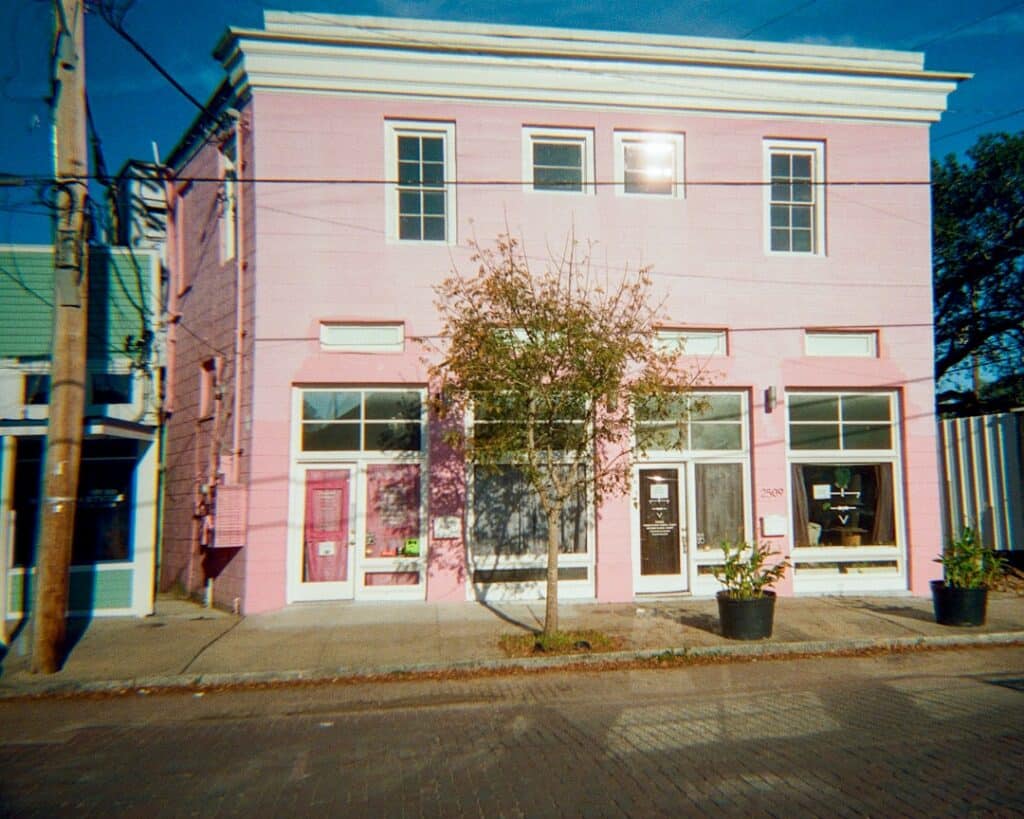 Vibrant, colorful shotgun house in New Orleans, situated right next to the street, highlighting its charming architecture ...