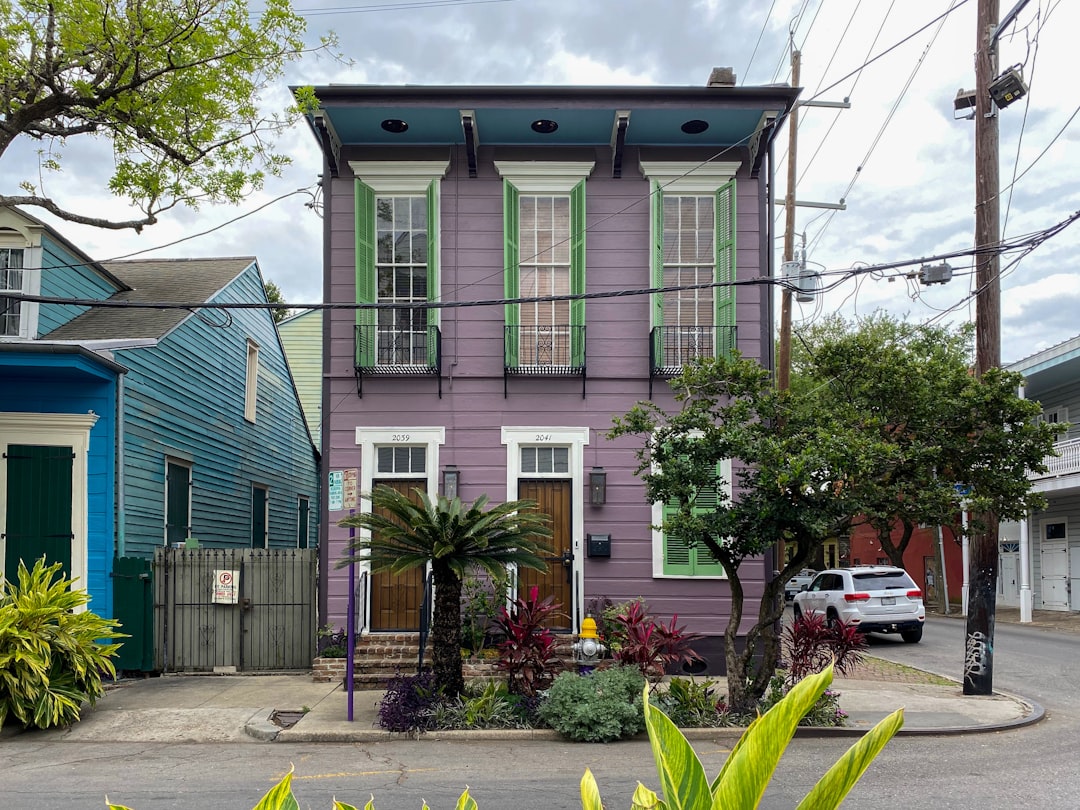 A classic New Orleans shotgun house on a visibly hot and humid day, representing the unique environmental challenges local homeowners face with moisture and heat.