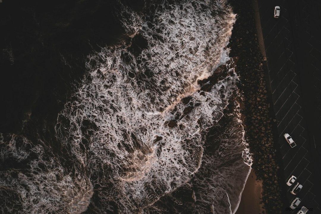 A detailed macro shot of old, wet, and failing fiberglass insulation between wooden studs in an attic, illustrating the root cause of mold damage.