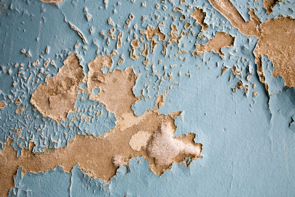 A large, ominous water stain spreading across a home's ceiling, symbolizing the hidden moisture problems discussed in the article on insulation failure.