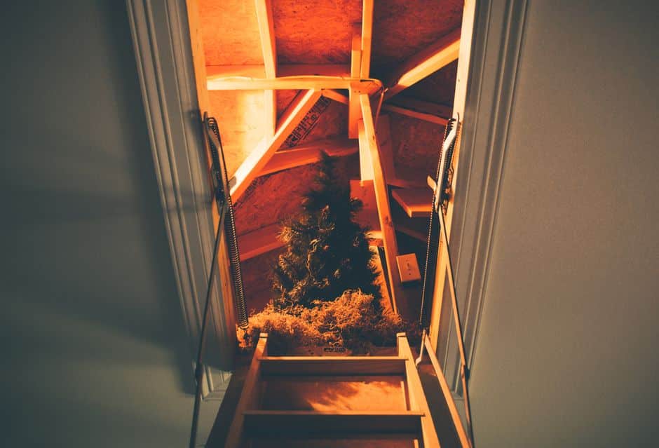 A clean, well-lit shot of a contractor expertly applying fresh, white spray foam insulation to the underside of a roof in an attic.