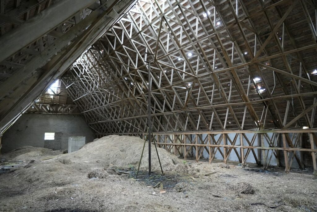 Close-up photograph showing wet, clumpy, and damaged blown-in insulation in an attic after a water leak, highlighting the ...