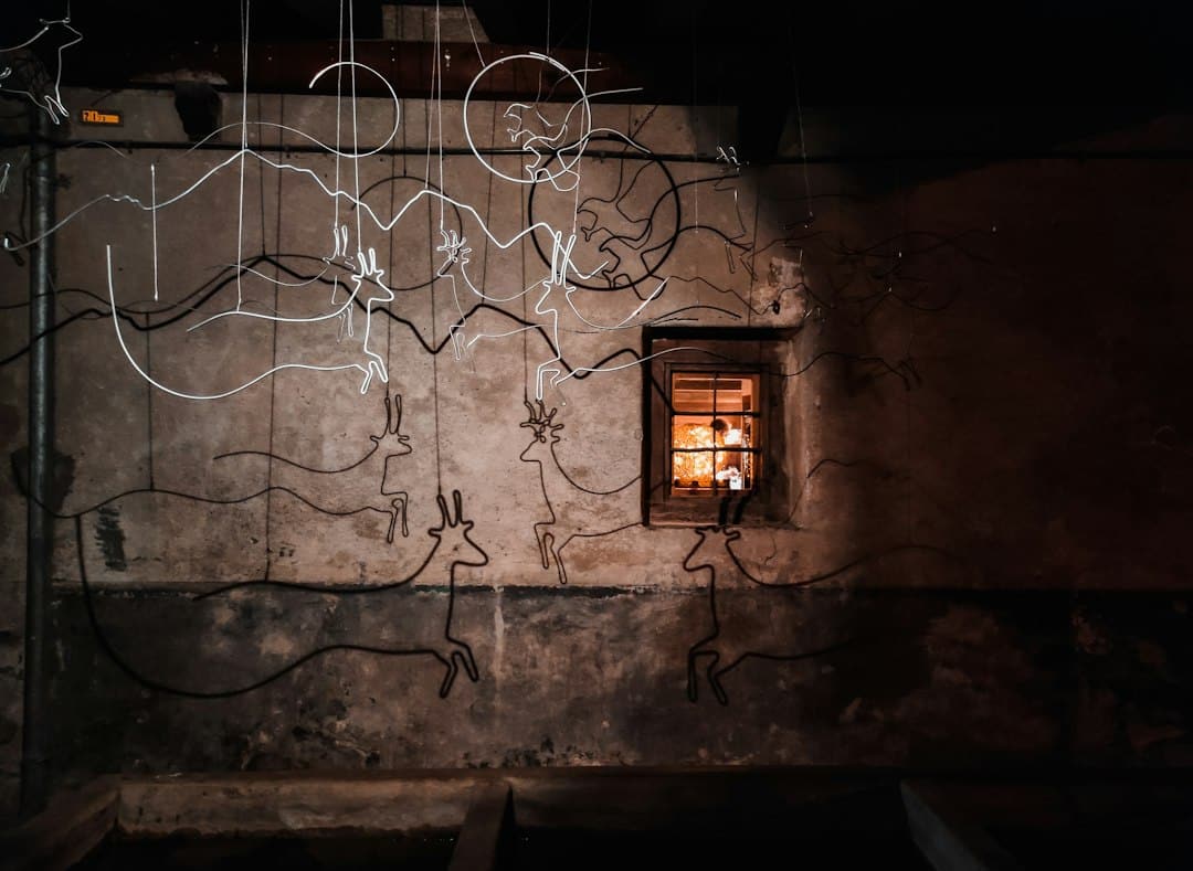 A professional electrician carefully working on a complex set of wires inside an open wall, illustrating a trade that often needs to cut through insulation.