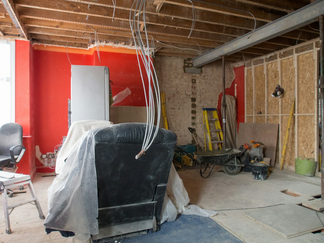 Spray foam insulation expanding and covering electrical wires inside a wall under dramatic lighting, visually representing the hidden fire hazard.